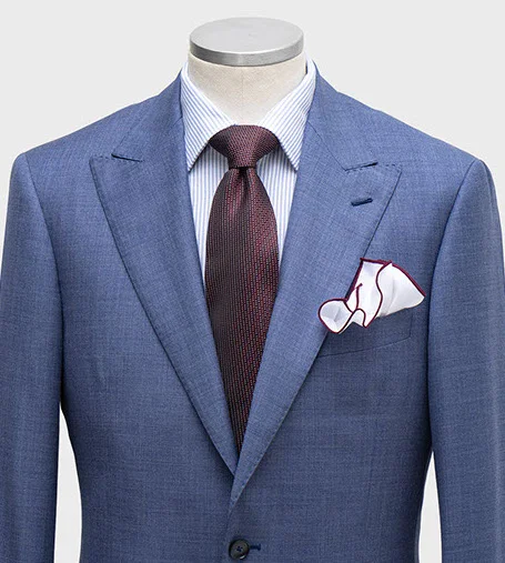 Mannequin wearing blue blazer, white shirt, burgundy tie, and white pocket square.