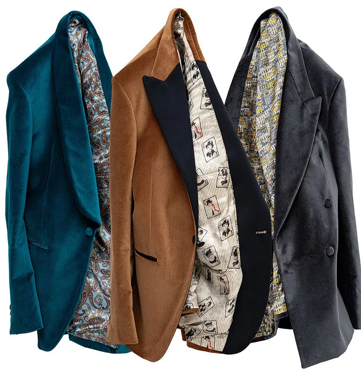 Three hanging suit jackets in dark green, brown, and dark gray with patterned linings.