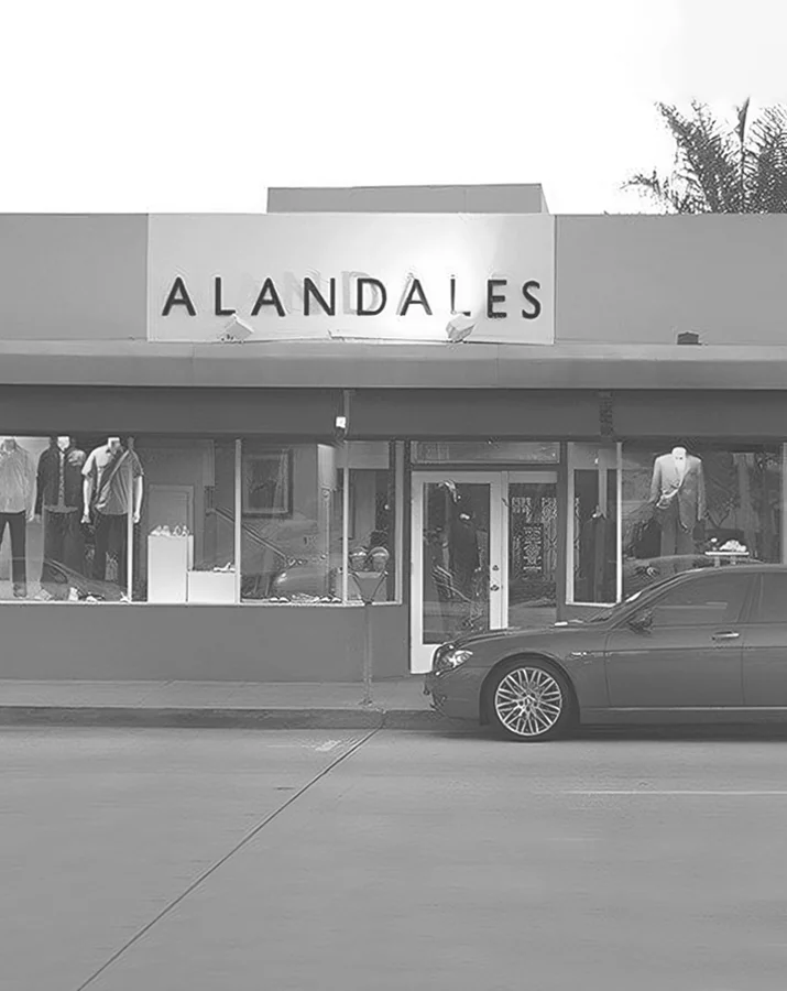 ALANDALES boutique storefront with mannequins wearing formal suits and high-end casual menswear, conveying classic elegance.