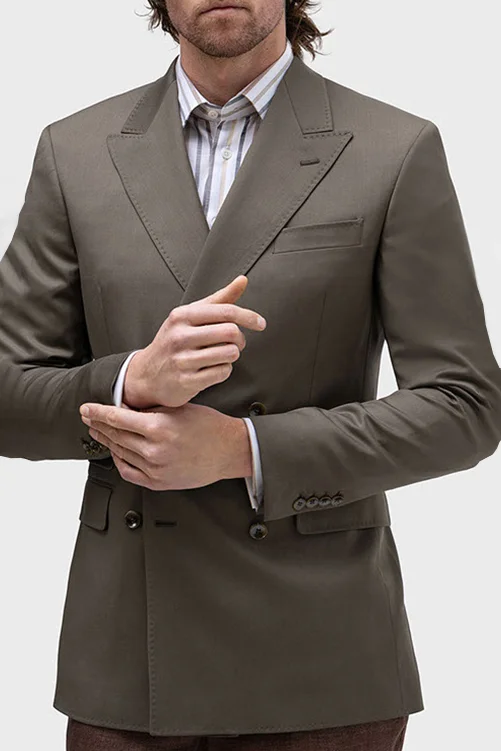Close-up of a model adjusting a dark green suit sleeve, wearing a striped shirt, no face visible.