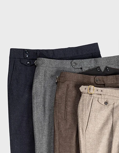 Stack of four dress pants in black, gray, brown, and beige colors.